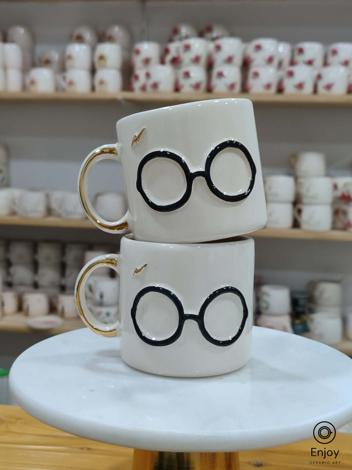 A stack of handmade ceramic mugs capturing the magic of a familiar wizarding world, each featuring classic round glasses and a golden lightning bolt. Perfect for cozy moments filled with charm and nostalgia.
