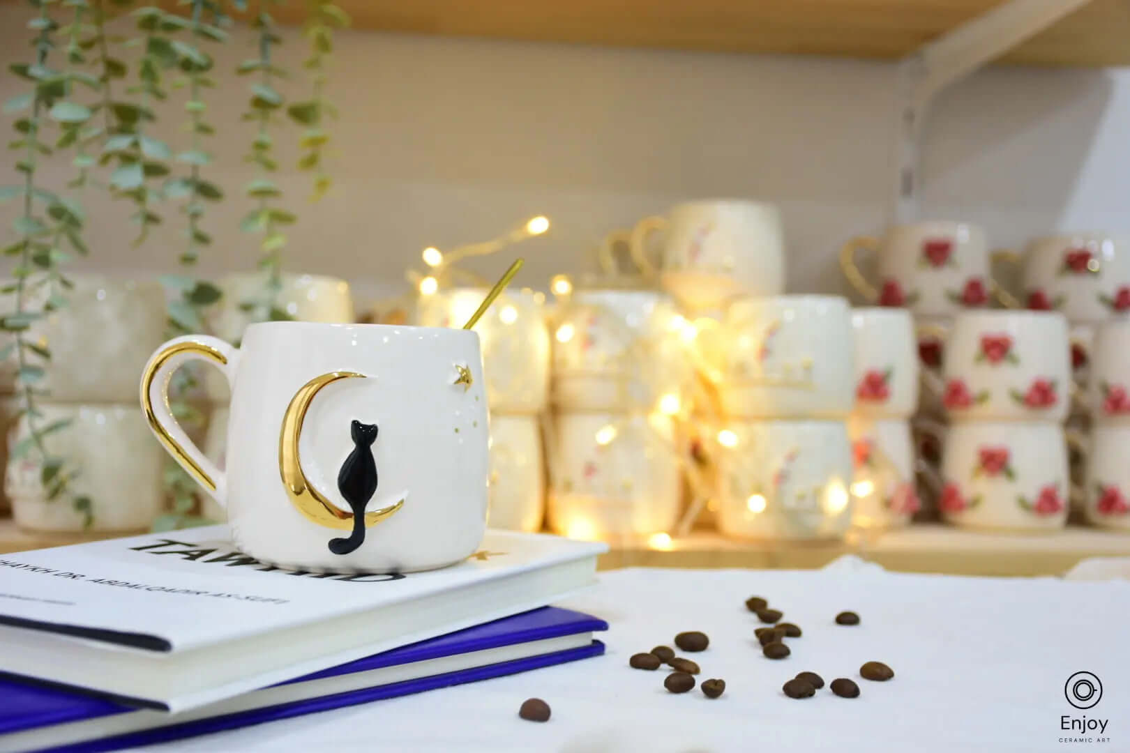 In this cozy setup, the celestial cat mug takes center stage, resting atop a stack of books with coffee beans scattered nearby. The black cat sits poised on a golden crescent moon, creating a magical and whimsical atmosphere, enhanced by warm, glowing fairy lights in the background. The mug's delicate golden handle and star accents make it an enchanting addition to any coffee or tea ritual, perfect for moments of quiet reflection or daydreaming.