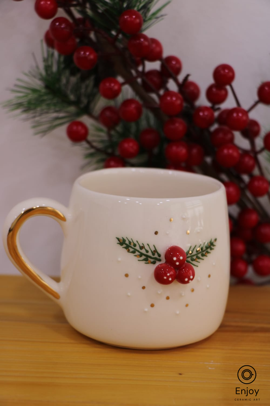 White mug with red berry design on a wooden surface with red berries in the background