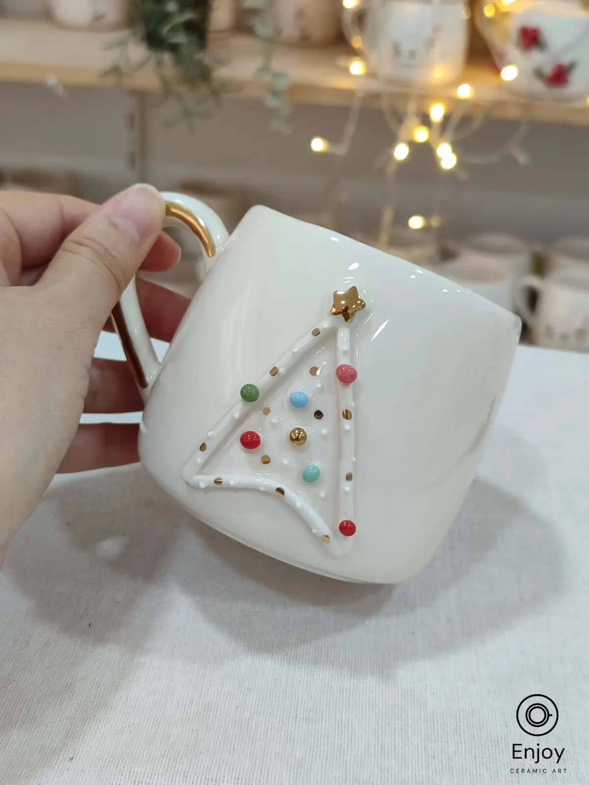 A handmade Star Trek-inspired ceramic Christmas mug featuring a 3D Christmas tree with colorful baubles, a gold star, and a gold handle, perfect for Trekkie fans.