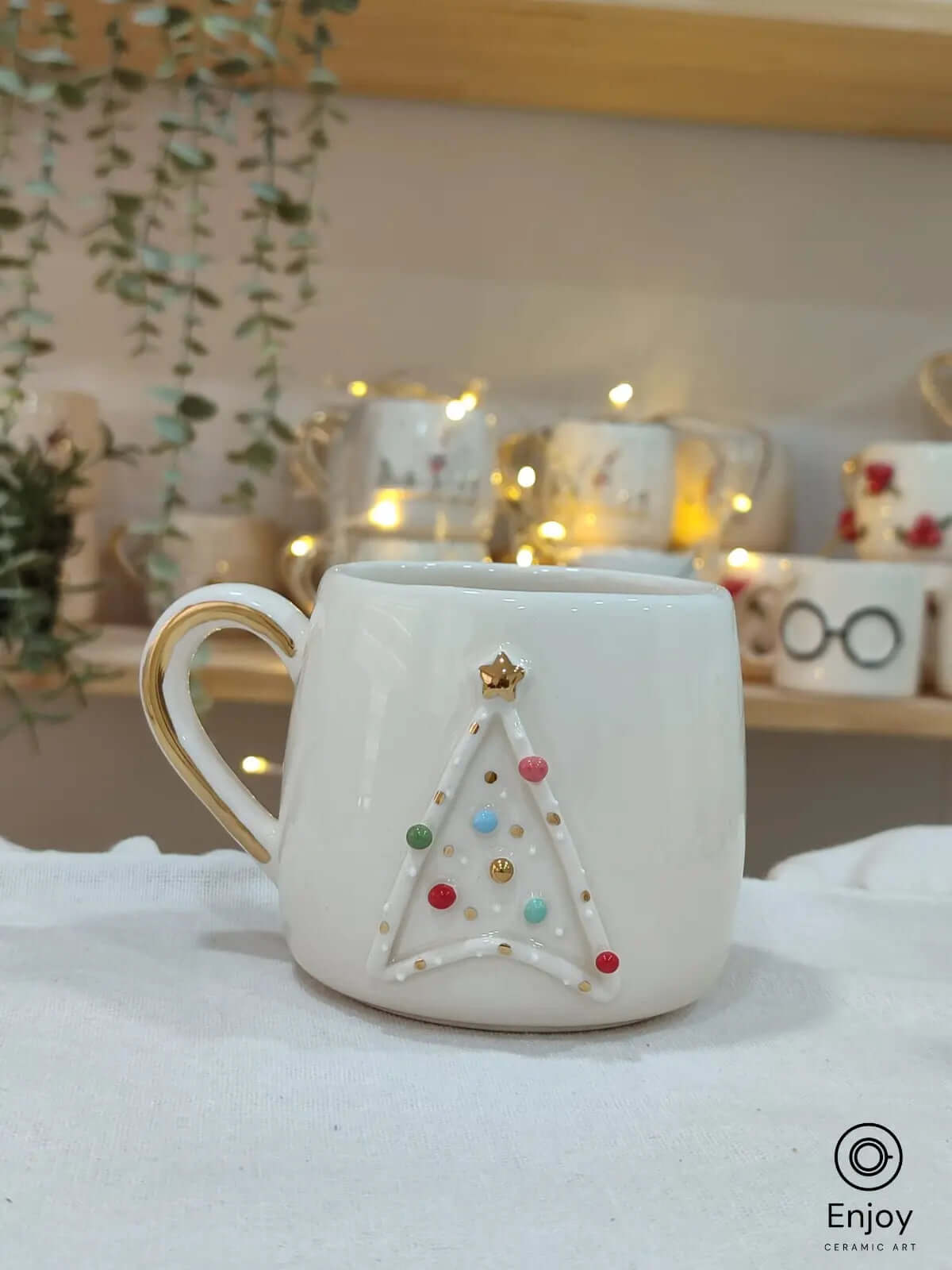 A handmade Star Trek-inspired ceramic Christmas mug featuring a 3D Christmas tree with colorful baubles, a gold star, and a gold handle, perfect for Trekkie fans.