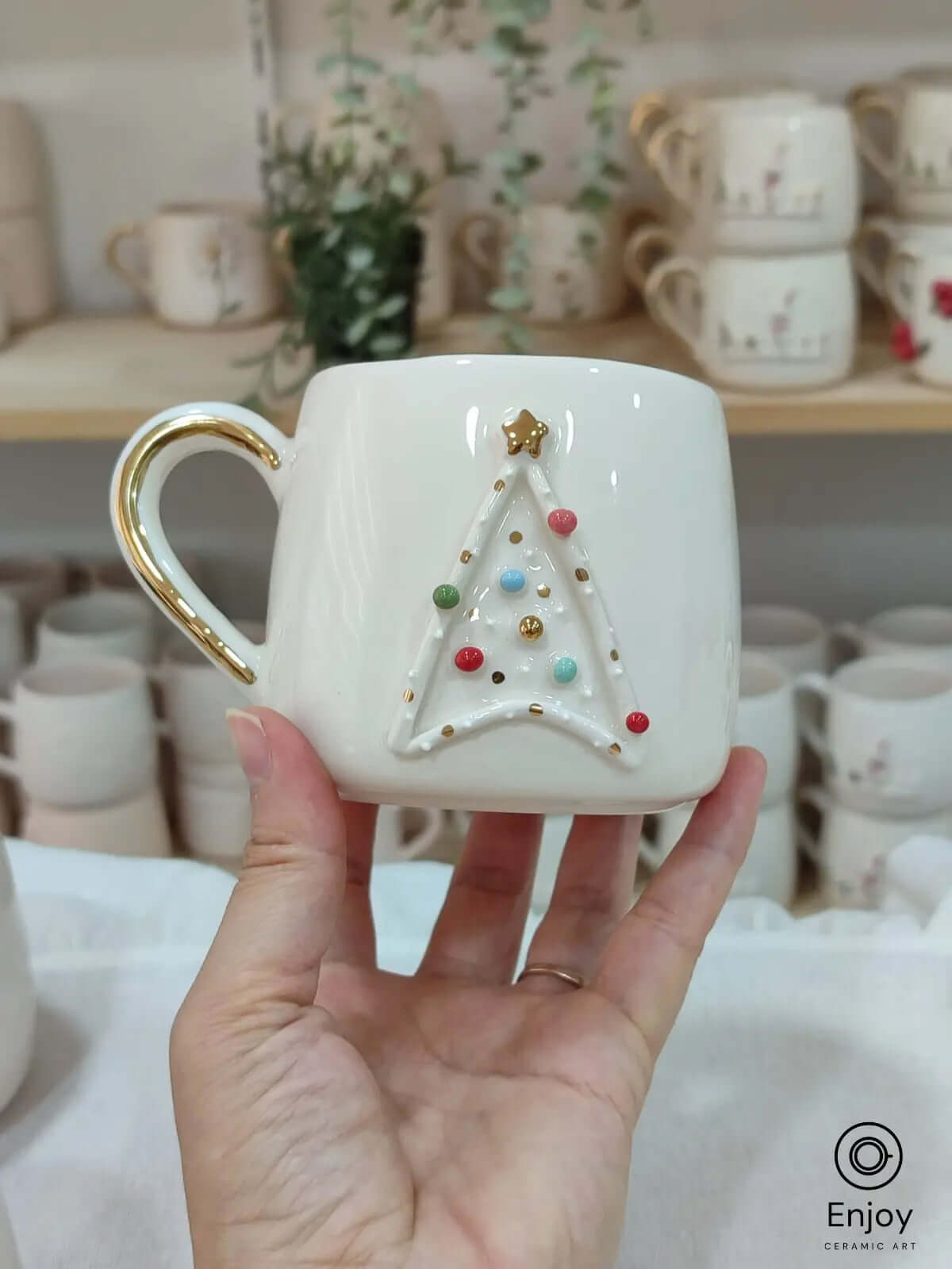 A handmade Star Trek-inspired ceramic Christmas mug featuring a 3D Christmas tree with colorful baubles, a gold star, and a gold handle, perfect for Trekkie fans.