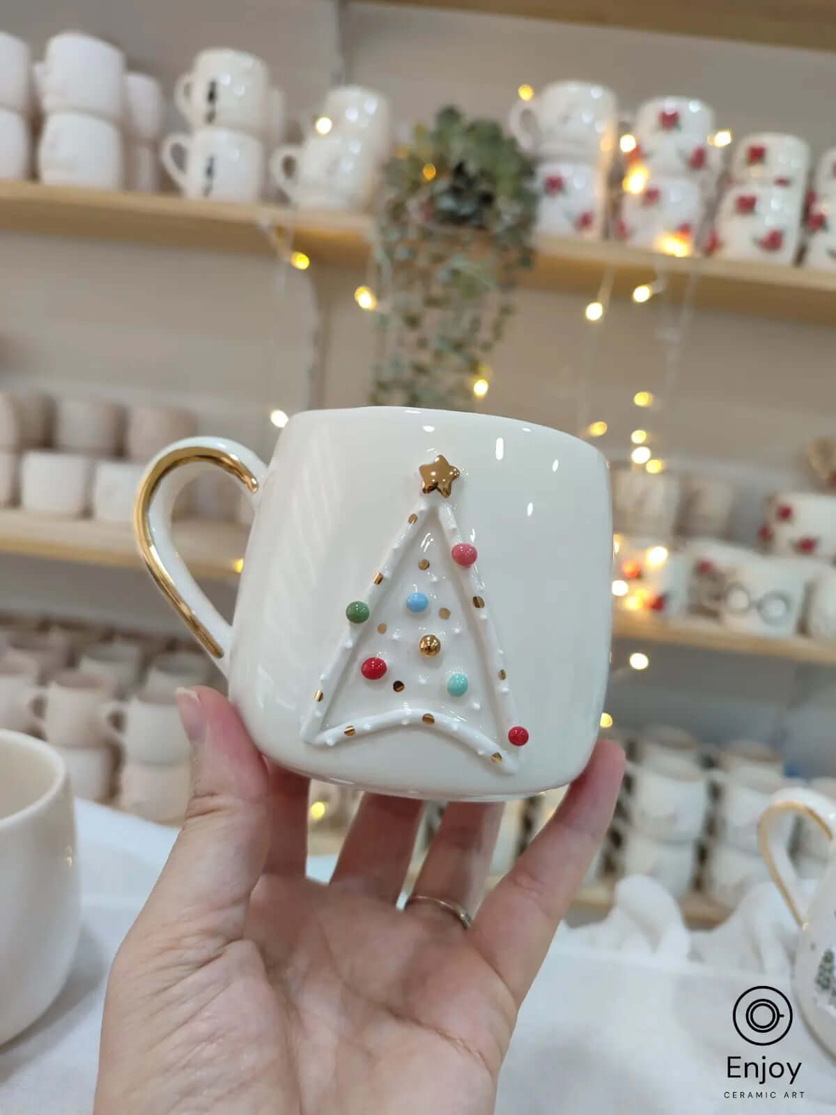 A handmade Star Trek-inspired ceramic Christmas mug featuring a 3D Christmas tree with colorful baubles, a gold star, and a gold handle, perfect for Trekkie fans.