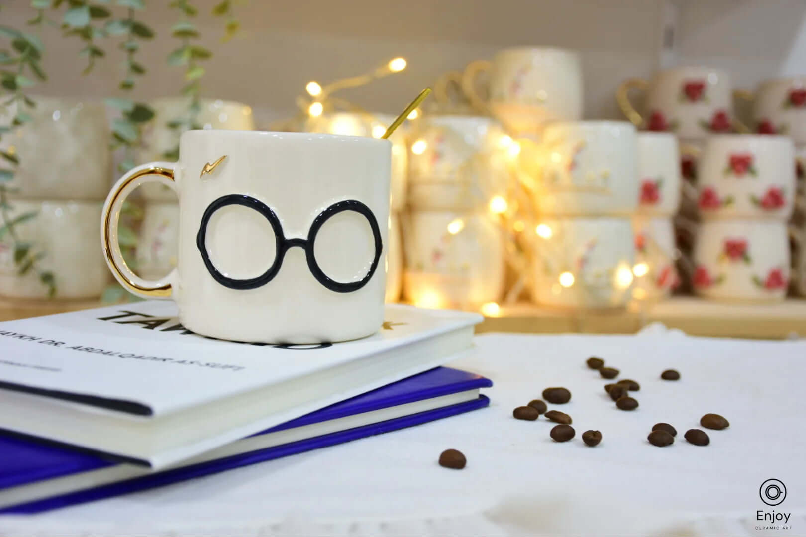 A whimsical ceramic mug featuring round glasses with gold accents, perfect for a magical touch. Set on a book with coffee beans nearby.